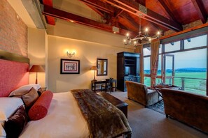 Une chambre d’hôtel avec un grand lit, un bureau, une chaise et une vue sur l’extérieur.