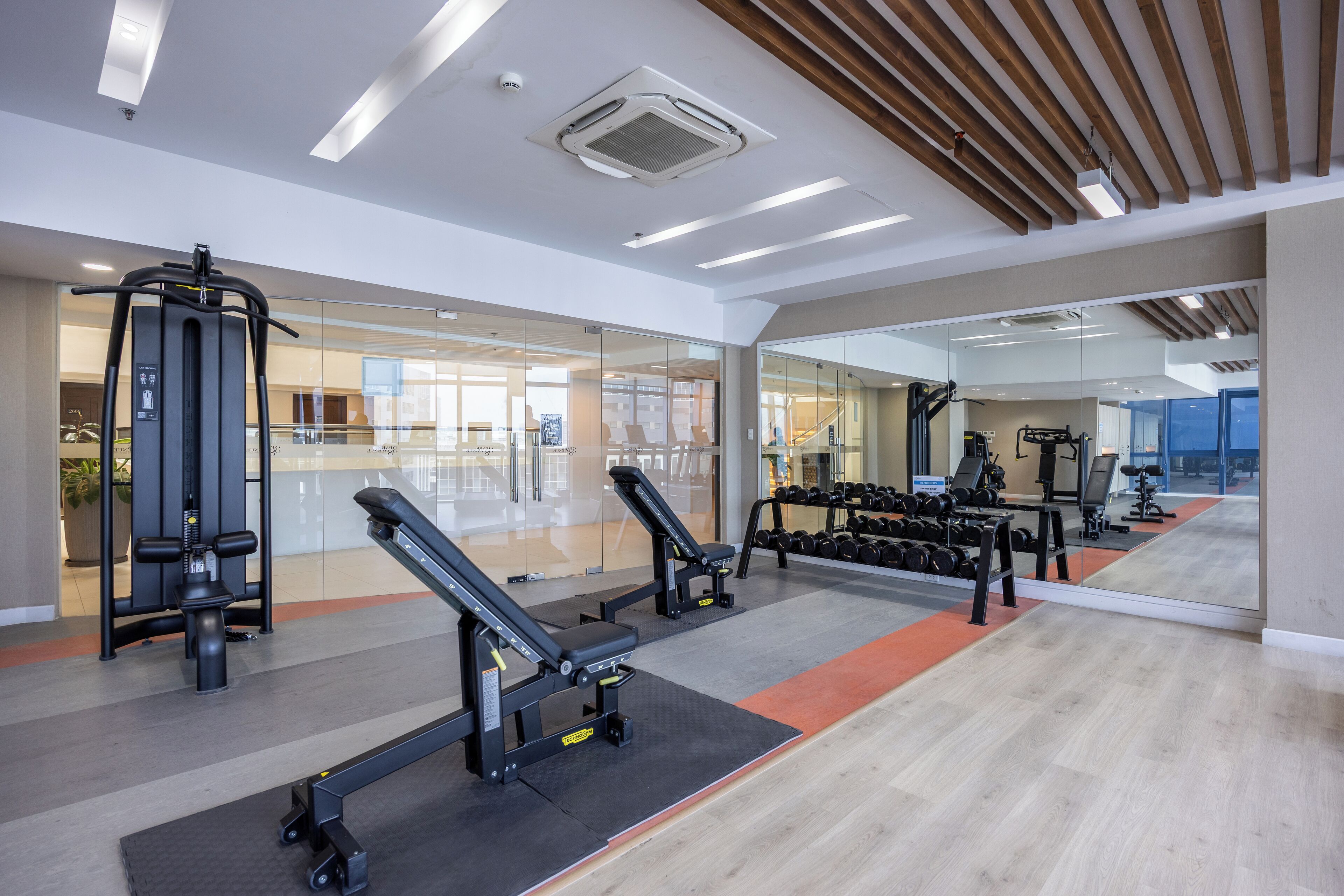 A modern gym with various exercise equipment, including weight machines and dumbbells.