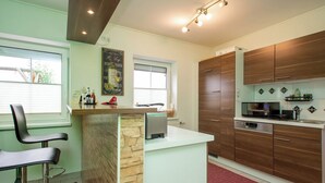 Una cocina moderna con pared de piedra decorativa, armarios de madera y microondas integrado.