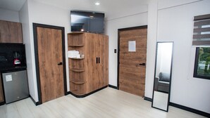 Une chambre moderne avec des armoires en bois, un téléviseur encastré et un miroir.
