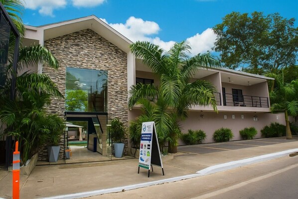 A modern building with a stone facade, large windows, and a balcony. - OCEAN DRIVE LODGE MONTAÑITA (Montañita)
