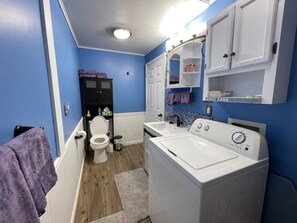 Un bagno compatto con il water, un lavandino e una lavatrice.