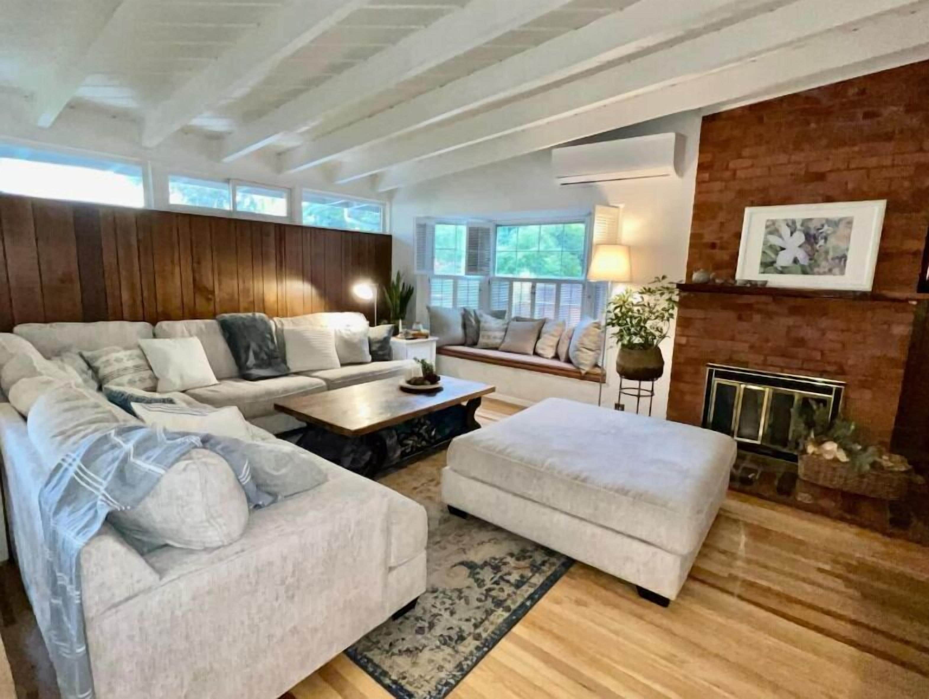A living room with a large sofa, a smaller sofa, a coffee table, and a fireplace.
