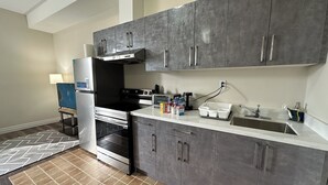 A modern kitchen with grey cabinets, a stainless steel stove, and a built-in oven.