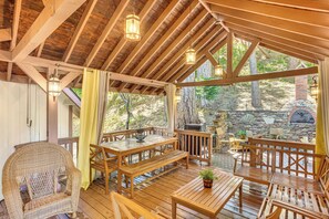 A covered patio with wooden furniture, stone walls, and hanging lanterns. - 1 Mi to Lake Gregory! Forest-View Crestline Cabin (Crestline)