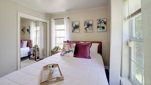 A bedroom with a large bed, a wooden tray, and a view of another room. - 1 Mi to Tulsa Arts District: Home w/ Yard! (Tulsa)