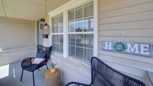 A covered porch with two wicker chairs, a small round table with a plant, and a 'HOME' sign on the wall. - 1 Mi to Tulsa Arts District: Home w/ Yard! (Tulsa)