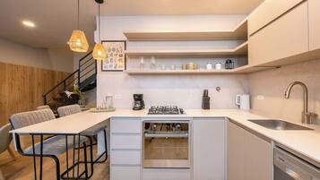 Una cocina moderna con una isla central, horno empotrado y electrodomésticos de acero inoxidable.