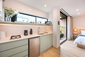 A modern kitchen with a built-in dishwasher, a coffee machine, and a microwave.