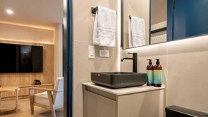 A modern bathroom with a large mirror, a sink with soap dispensers, and a chair. - Digital Nomad Paradise 3 units-4BR w/ AC in Manila (Medellín)