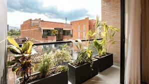 A balcony with potted plants and a view of a brick building. - Digital Nomad Paradise 3 units-4BR w/ AC in Manila (Medellín)