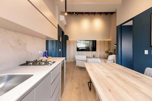 A modern kitchen with a wooden dining table, built-in cabinets, and a large window.