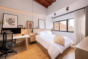 Une chambre à coucher moderne avec un lit, un bureau et un ordinateur.