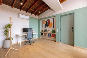 Um espaço de escritório moderno com uma mesa de madeira, cadeira de escritório e uma planta em vaso.