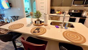 Une cuisine dotée d’un îlot central, d’un four à micro-ondes, d’un grille-pain et d’un évier.