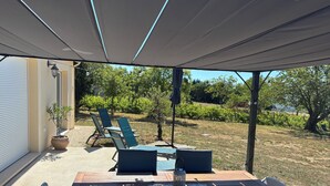 An outdoor patio with a table and chairs, a potted plant, and a view of a vineyard. - La vigne" house in the countryside near Sarlat with beautiful view! (Marcillac-Saint-Quentin)