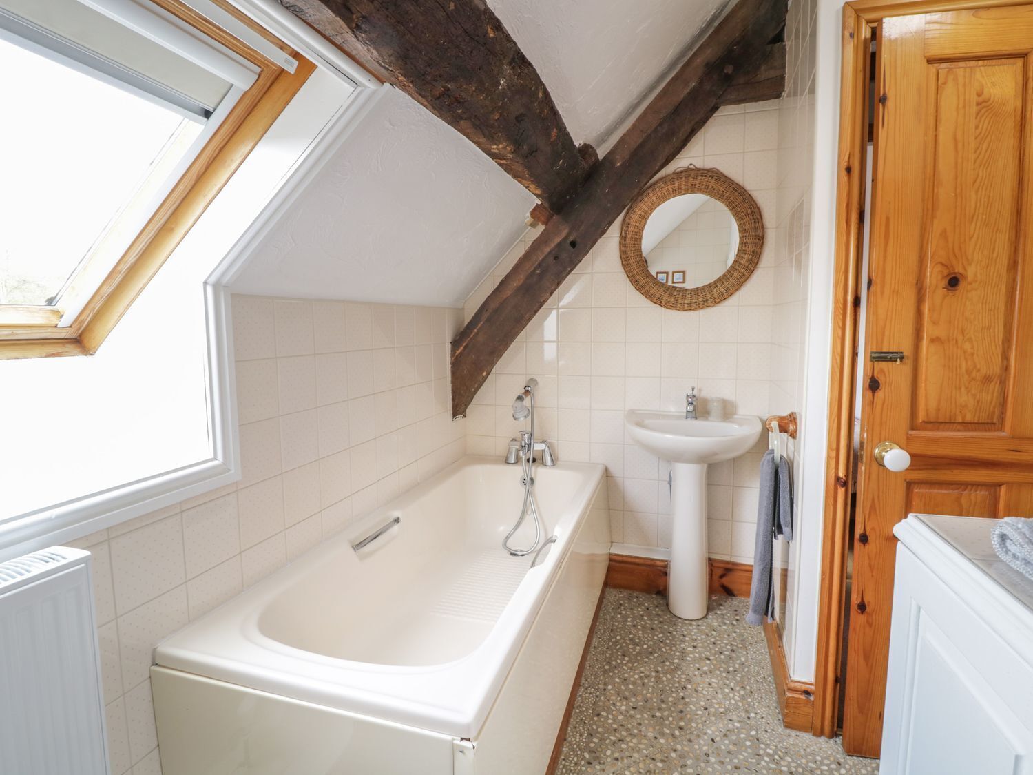 A bathroom with a bathtub, a sink, and a mirror.