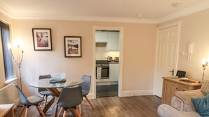 Un espace de vie compact comprenant un coin repas, une kitchenette et un canapé.