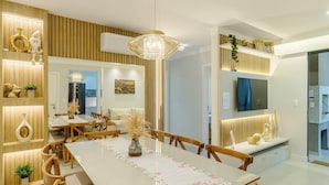 Un comedor moderno con una mesa larga, paneles de madera e iluminación decorativa.