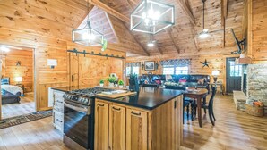 Une cuisine spacieuse avec des meubles en bois, un îlot central et des luminaires suspendus.
