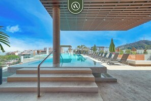 A rooftop pool area with a clear view of the cityscape and a mountain in the distance. - V399 108 | 1BR/1BA Puerto Vallarta | Near Ocean, Pool, Rooftop (Puerto Vallarta)