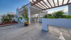A rooftop terrace with a pergola, potted plants, and outdoor furniture. - Amazing 1BR - Rooftop Pool in Versalles (Puerto Vallarta)