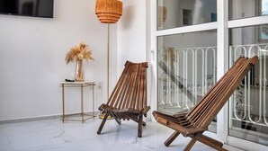 A modern interior with two wooden chairs, a floor lamp, and a small table with a vase. - Amazing 1BR - Rooftop Pool in Versalles (Puerto Vallarta)