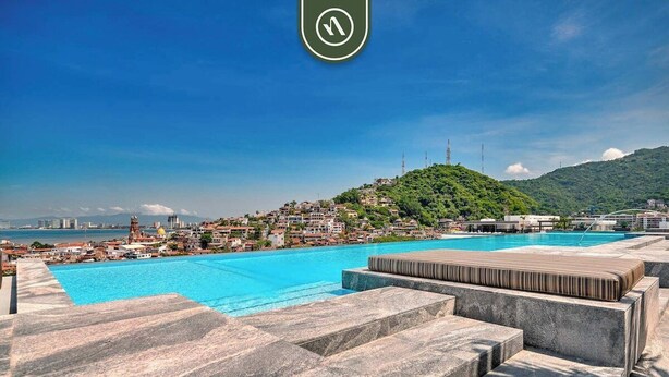 A rooftop pool with a view of a cityscape and a hill. - Amazing 1 BR Condo with Terrace - Rooftop Pool (Puerto Vallarta)