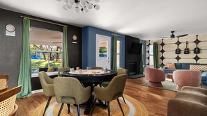 A modern living room with a round table, chairs, a sofa, and a fireplace. - NEW Villa w/ Pool•HotTub•GameRoom•Movie•Sleeps20 (Austin)
