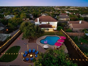 A residential backyard with a swimming pool, outdoor seating, and a fire pit. - NEW Villa w/ Pool•HotTub•GameRoom•Movie•Sleeps20 (Austin)