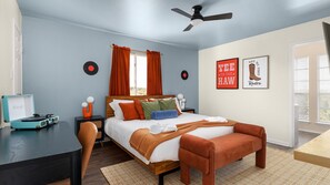 A bedroom with a bed, a desk, a record player, and two wall art pieces. - NEW Villa w/ Pool•HotTub•GameRoom•Movie•Sleeps20 (Austin)