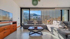 Una sala moderna con un sofá, una mesa de centro y un televisor.