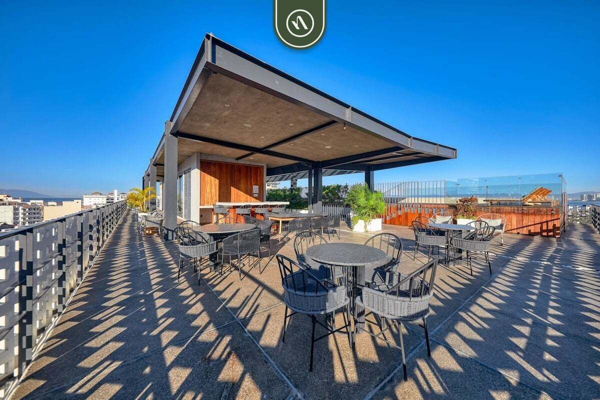En takterrass med utomhusmöbler, ett överbyggt område och utsikt över stadsbilden.