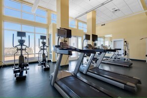 A gym with treadmills, stationary bikes, and weight machines.