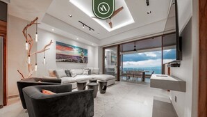 A modern living room with a sofa, a black armchair, a coffee table, and a painting on the wall. - "Private Ocean Sanctuary | Quiet Luxury." (Puerto Vallarta)