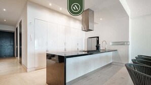A modern kitchen with white cabinets, a black countertop, and a built-in stove. - Paramount Bay PH 5 | 3BR/4BA Penthouse, PV | Ocean Views, Rooftop Pool (Puerto Vallarta)