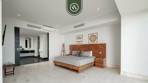 A modern bedroom with a large bed, wooden headboard, and a minimalist design. - Paramount Bay PH 5 | 3BR/4BA Penthouse, PV | Ocean Views, Rooftop Pool (Puerto Vallarta)