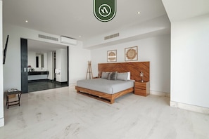A modern bedroom with a large bed, a wooden headboard, and a minimalist design.