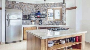 Eine moderne Küche mit einem Edelstahlkühlschrank, einer Mikrowelle und einem Gasherd.