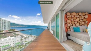 Un balcon avec un plancher en bois, un lit avec des oreillers et un mur décoré d’objets ronds.