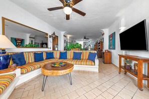 Un salon avec un canapé, une table basse et un ventilateur de plafond.