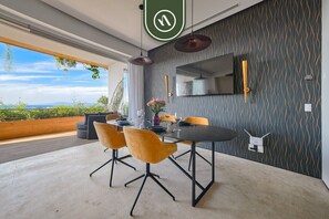 A modern dining area with a large table, yellow chairs, and a view of the outdoors. - SoHo PV 806 | 1BR/2BA Puerto Vallarta | Beach, Pool, Gym (Puerto Vallarta)