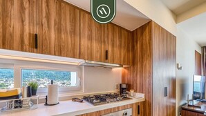 Une cuisine moderne avec des meubles en bois, une cuisinière en acier inoxydable et un four encastré.