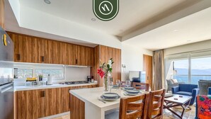 Une cuisine moderne avec des meubles en bois, un îlot central et un coin repas comprenant des chaises et une table.