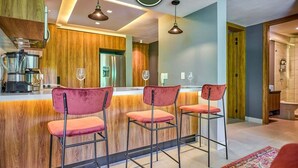 A modern kitchen with wooden accents, a bar area with red chairs, and pendant lighting. - Sea View Residences 302 | 2BR/2BA PV | Pool & Beach (Puerto Vallarta)