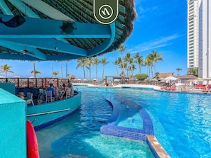 A pool area with a boat, palm trees, and a tall building in the background.