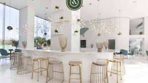 A modern bar area with high ceilings, large windows, and a minimalist design.