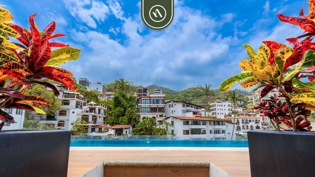 A poolside view with a clear sky, a pool, and buildings in the background. - Serenity 301 | 2BR Puerto Vallarta | Rooftop Pool (Puerto Vallarta)