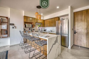 A modern kitchen with a marble island, stainless steel appliances, and pendant lighting. - 2 BR Condo in Romantic Zone - Pool - Terrace (Puerto Vallarta)