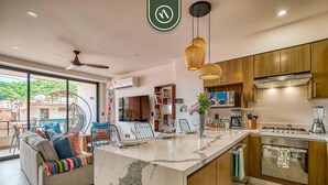 A modern kitchen with a marble island, wooden cabinets, and stainless steel appliances. - Serenity 301 | 2BR Puerto Vallarta | Rooftop Pool (Puerto Vallarta)